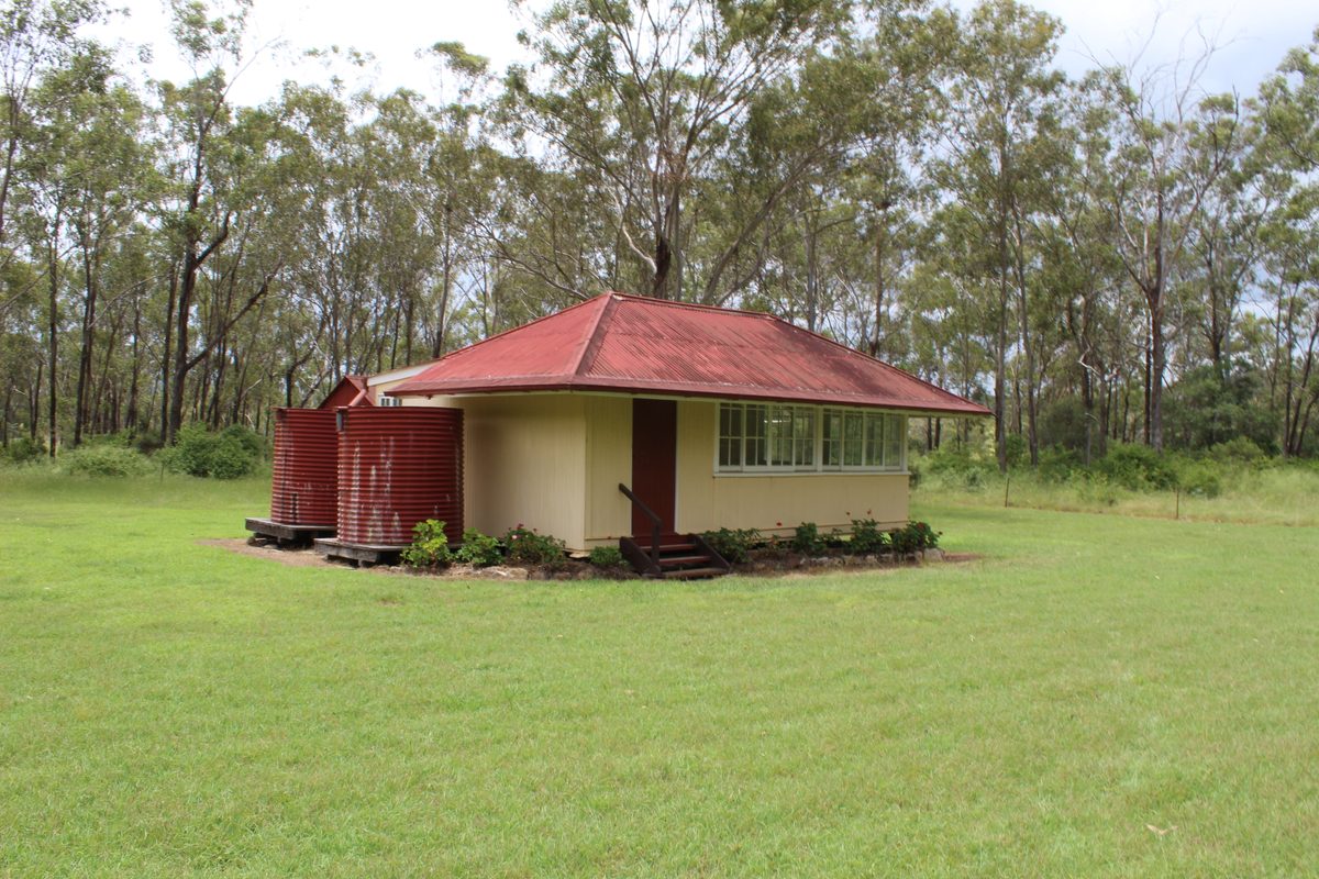 Restored school building at Monto Heritage Precinct under clear skies.